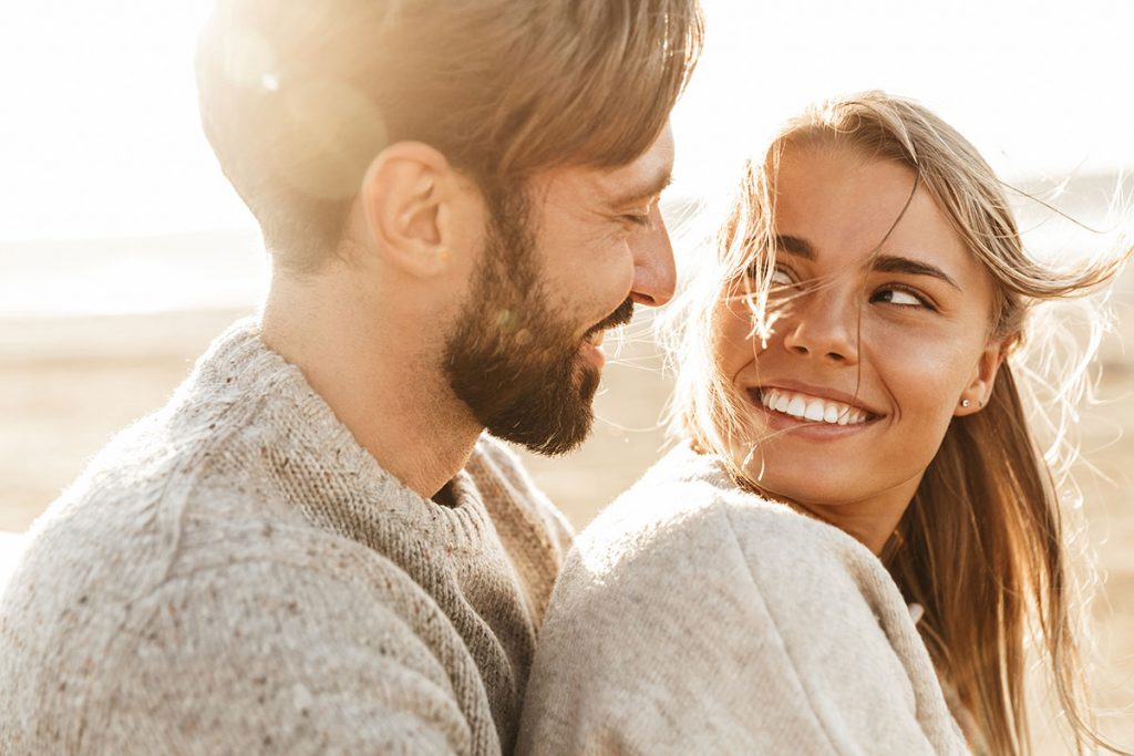 young man and woman looking at each other smiling