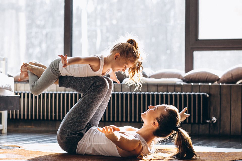 young female doing yoga together with child